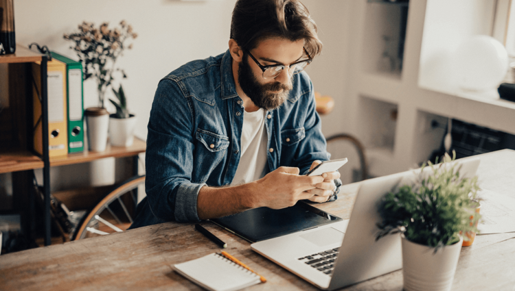 Un homme adulte travaille à l'intérieur avec la technologie dans un bureau, favorisant la créativité commerciale.