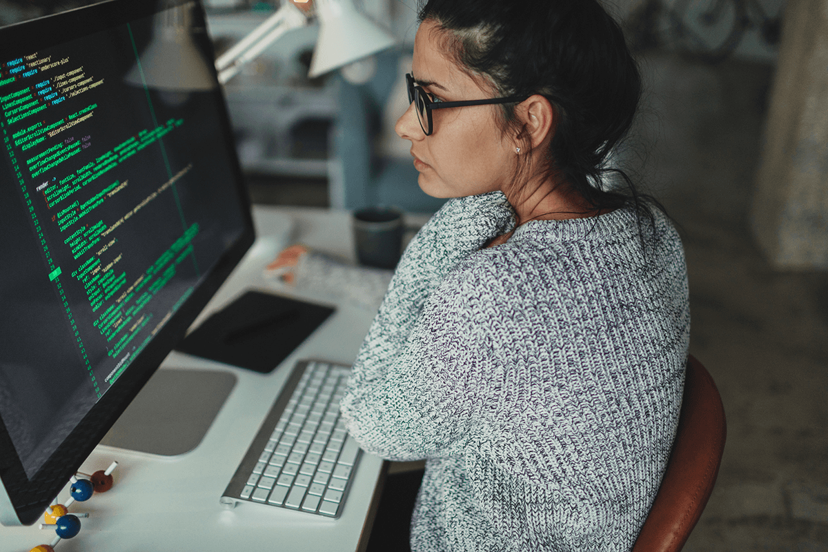 Une femme adulte travaille sur un ordinateur à l'intérieur d'un bureau, utilisant la technologie et internet.