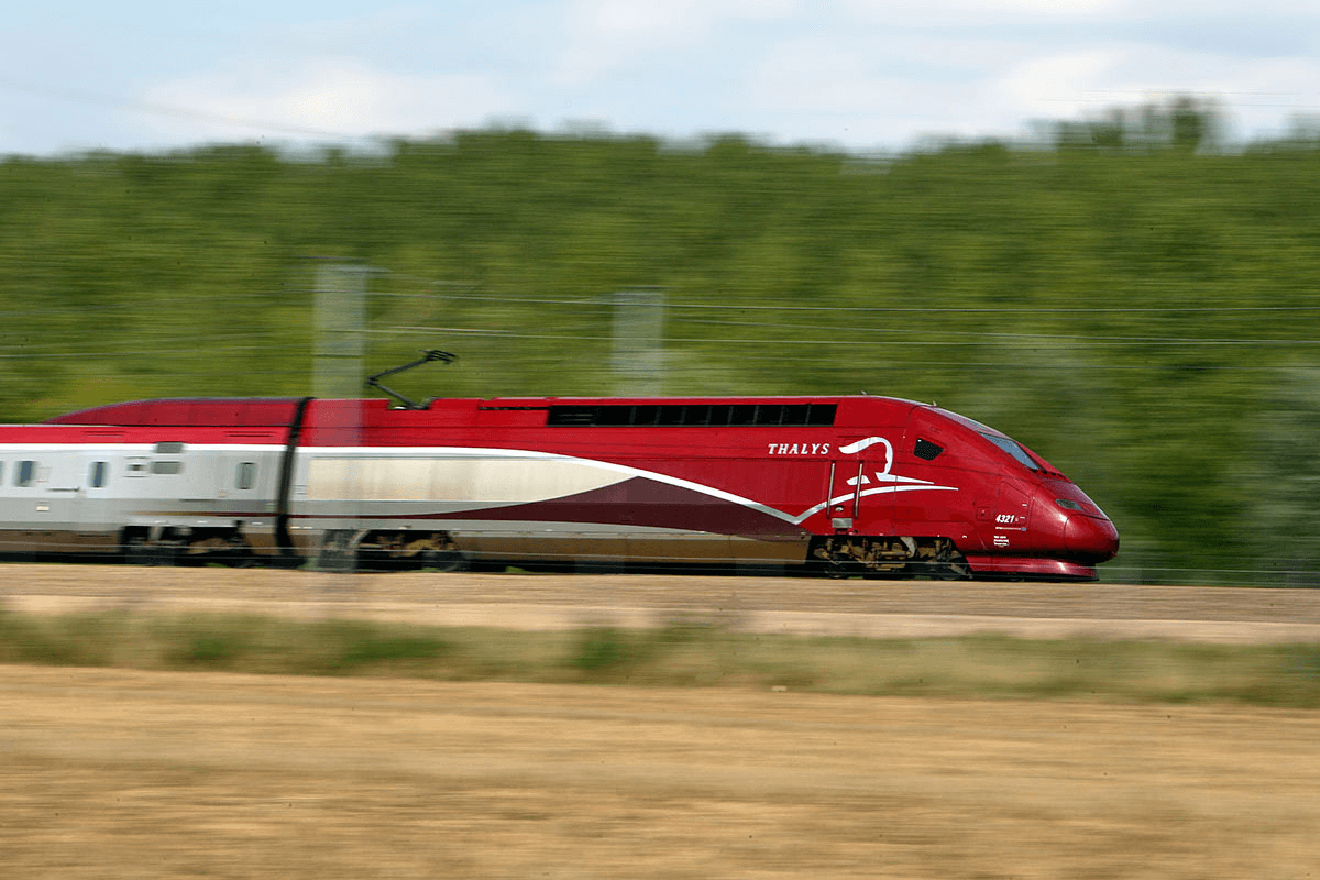 Une locomotive à grande vitesse se déplace le long des voies ferrées, ce qui rend le véhicule terrestre flou.