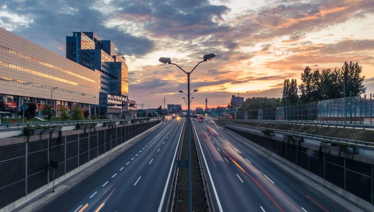 Paysage nocturne de la ville avec trafic crépusculaire et voitures - transport, architecture et vitesse de la vie urbaine.