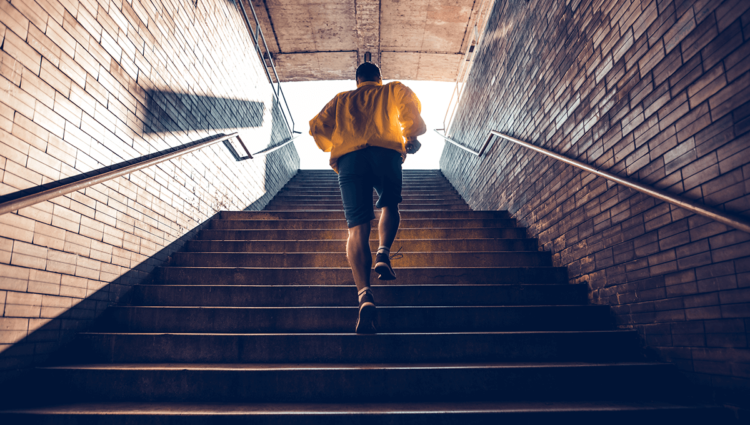 Un homme adulte est vu monter les marches d'un escalier intérieur, mettant en valeur la nature dynamique des modes de vie et de l'architecture.