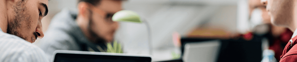 Close-up of an adult man indoors working on a computer